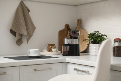 Modern coffee grinder on counter in kitchen