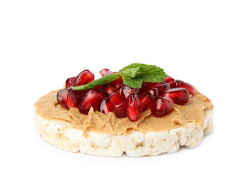 Photo of Puffed rice cake with peanut butter, pomegranate seeds and mint isolated on white