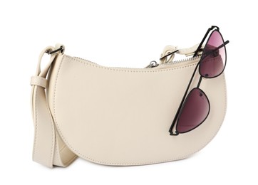 Photo of Stylish baguette bag with sunglasses on white background