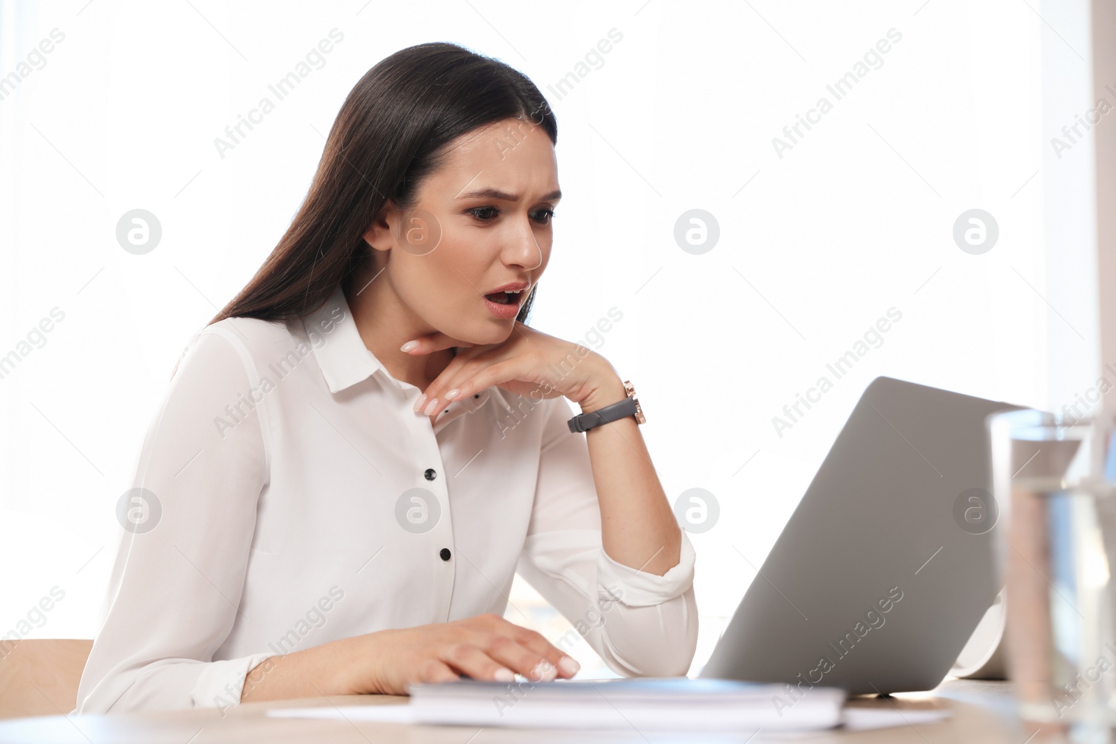 Photo of Young woman using video chat on laptop in home office