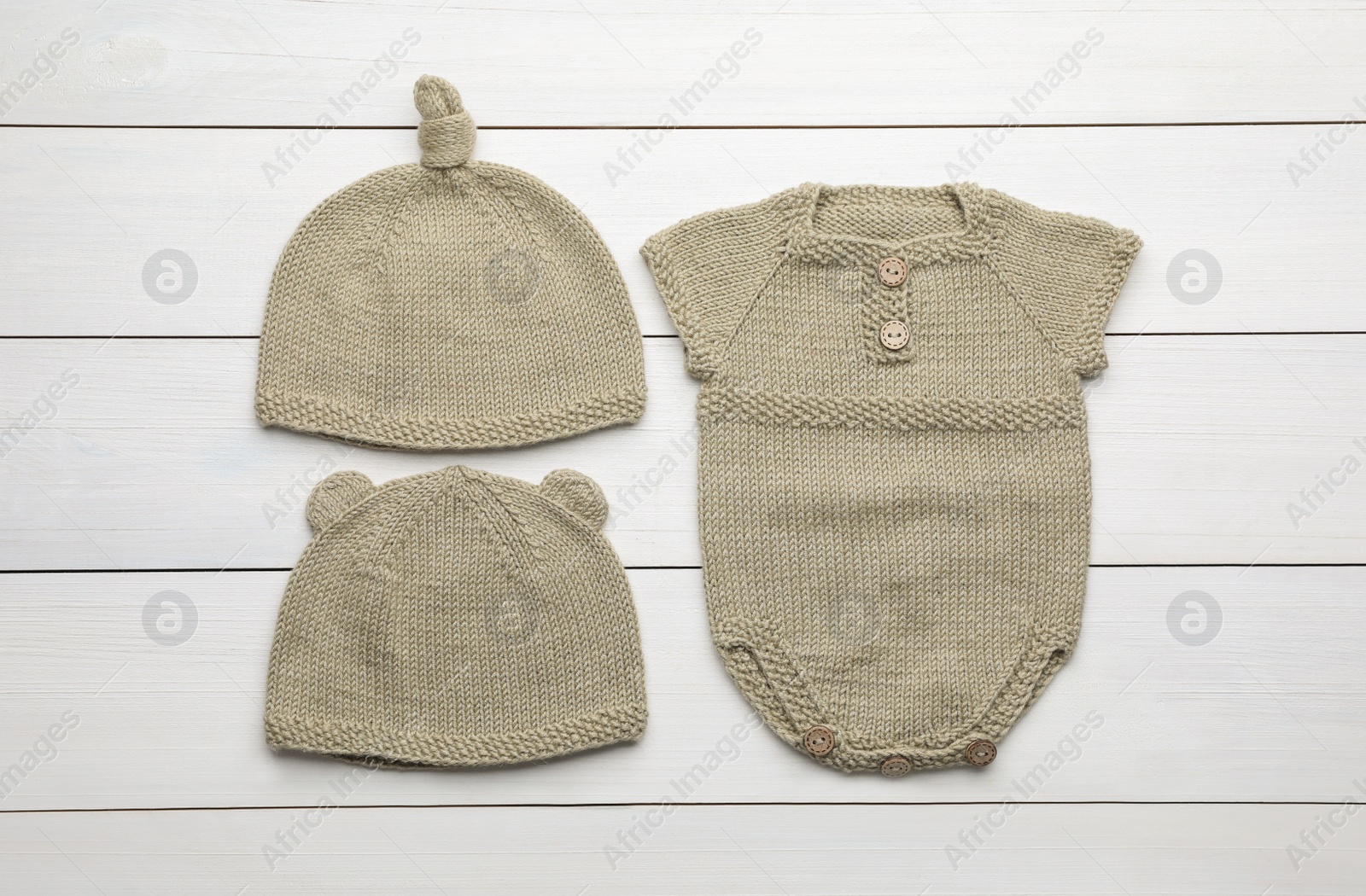 Photo of Flat lay composition with child's clothes on white wooden table