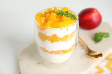 Photo of Tasty peach dessert with yogurt served on white table