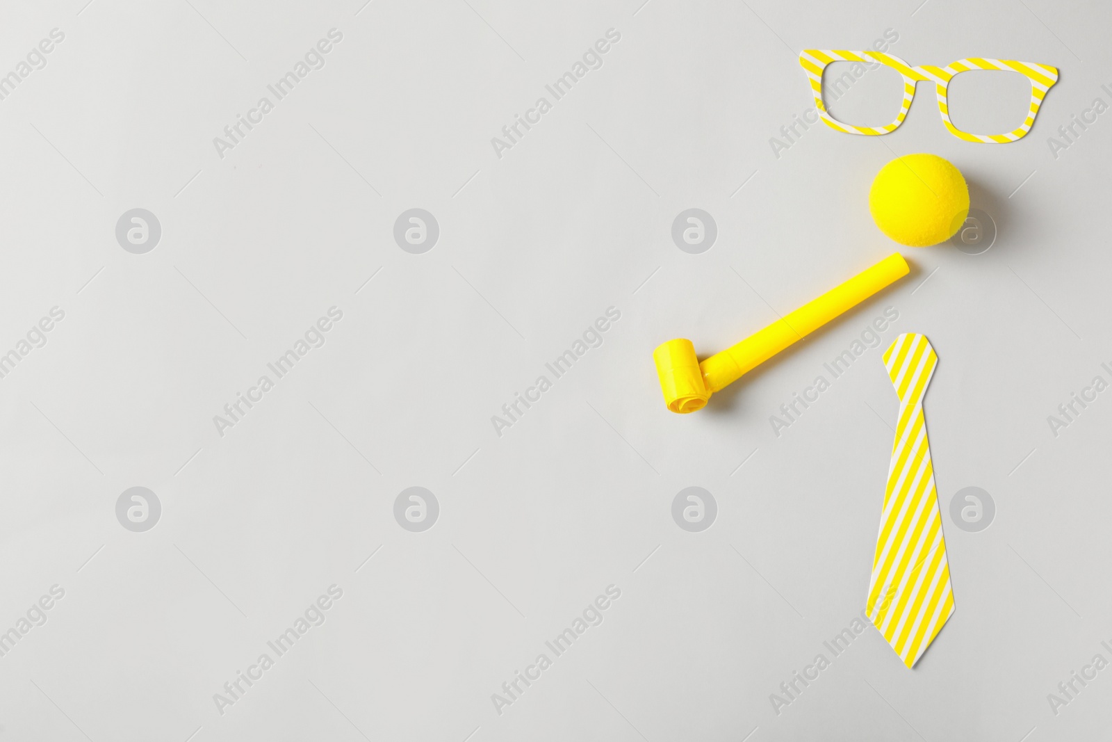 Photo of Different clown's accessories on light background, flat lay. Space for text