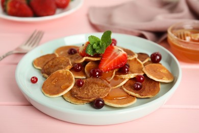 Photo of Cereal pancakes with berries on pink wooden table