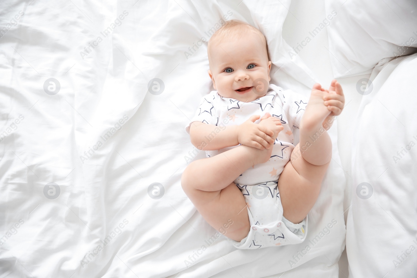 Photo of Cute little baby lying on bed, top view