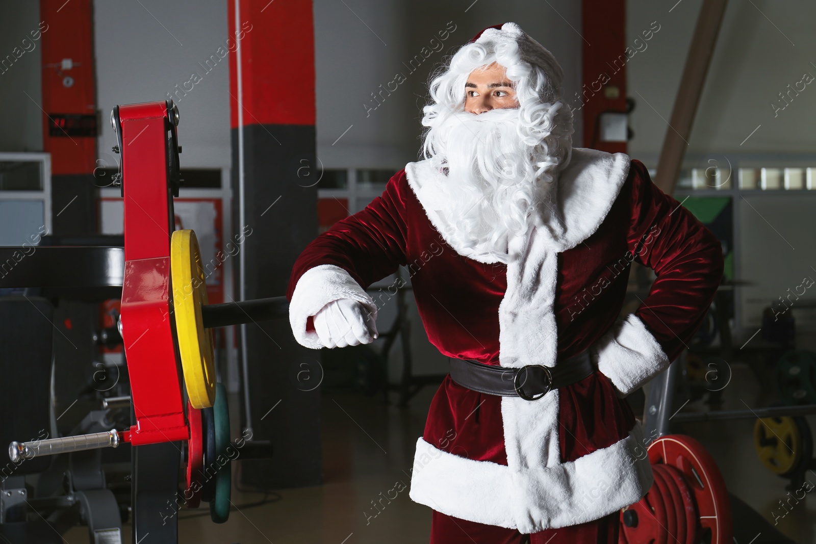 Photo of Young Santa Claus resting in modern gym