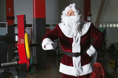 Photo of Young Santa Claus resting in modern gym