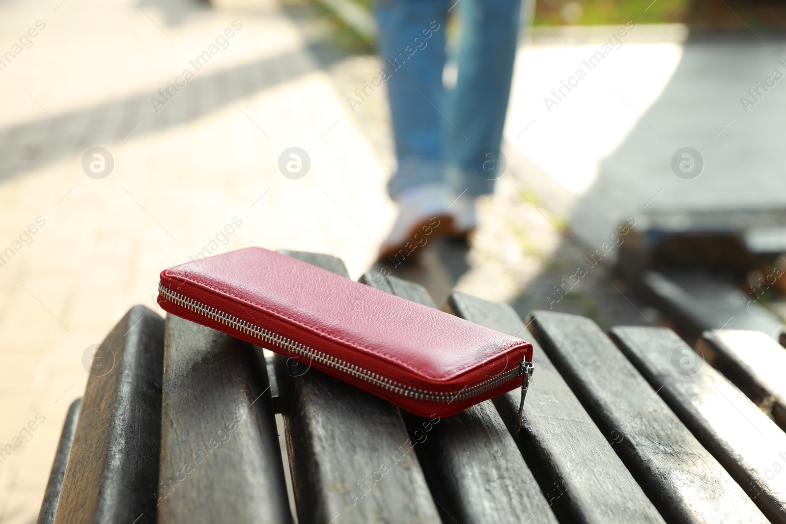 Photo of Woman lost her purse on wooden surface outdoors, selective focus. Space for text