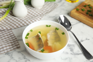 Photo of Delicious fish soup served on marble table