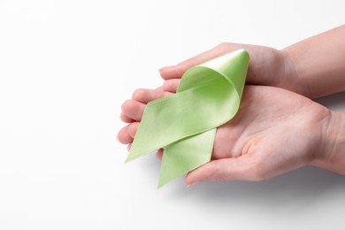 Photo of World Mental Health Day. Woman holding green ribbon on white background, closeup with space for text