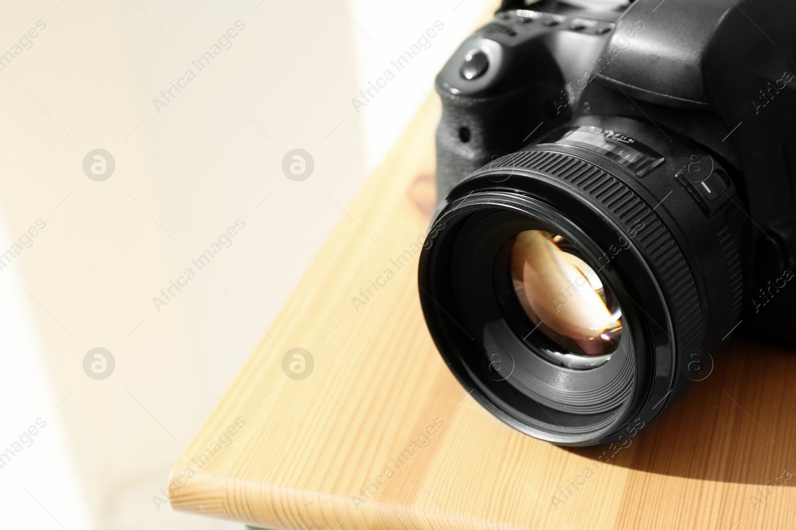 Photo of Professional camera on wooden table, space for text. Photographer's equipment