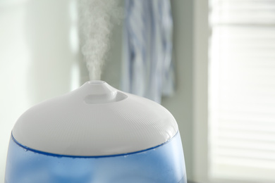 Photo of Modern air humidifier indoors, closeup. Space for text