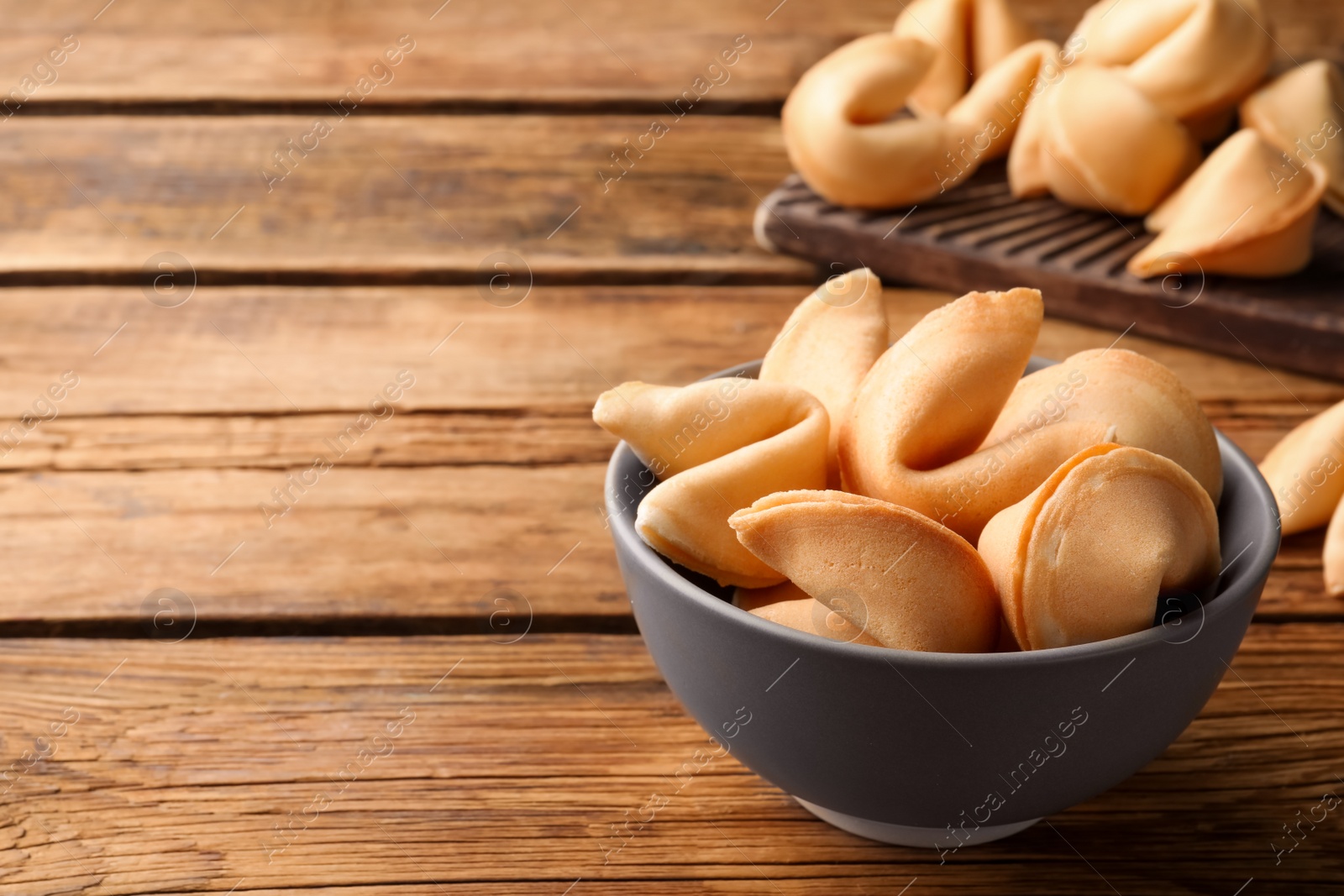 Photo of Tasty fortune cookies with predictions on wooden table, space for text