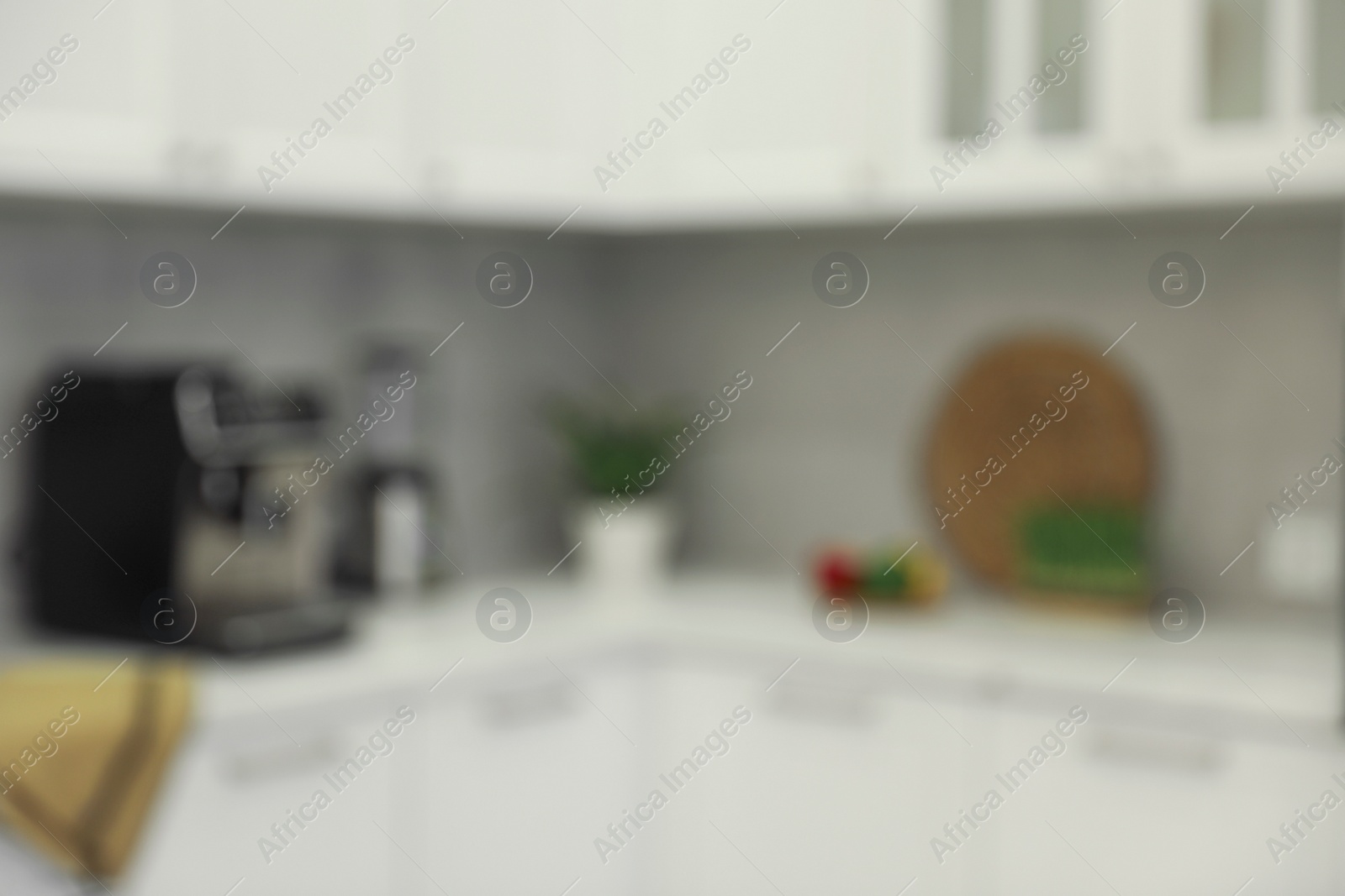 Photo of White stylish kitchen with furniture, blurred view. Interior design