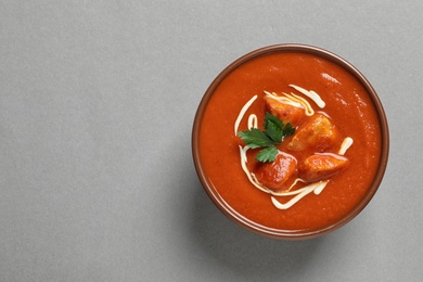 Bowl of delicious butter chicken on color background, top view with space for text. Traditional indian Murgh Makhani