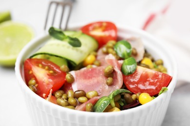 Photo of Bowl of salad with mung beans on white table, closeup