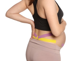Photo of Sporty pregnant woman with kinesio tapes on white background, closeup