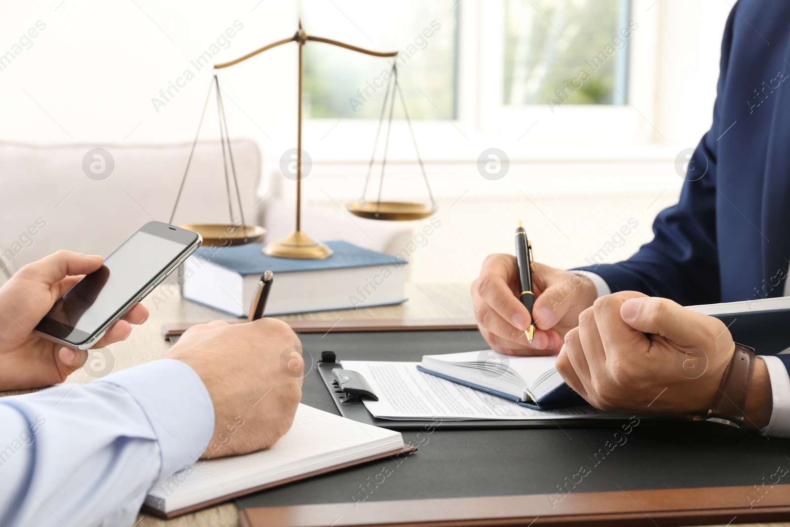 Photo of Lawyer working with client at table in office, focus on hands