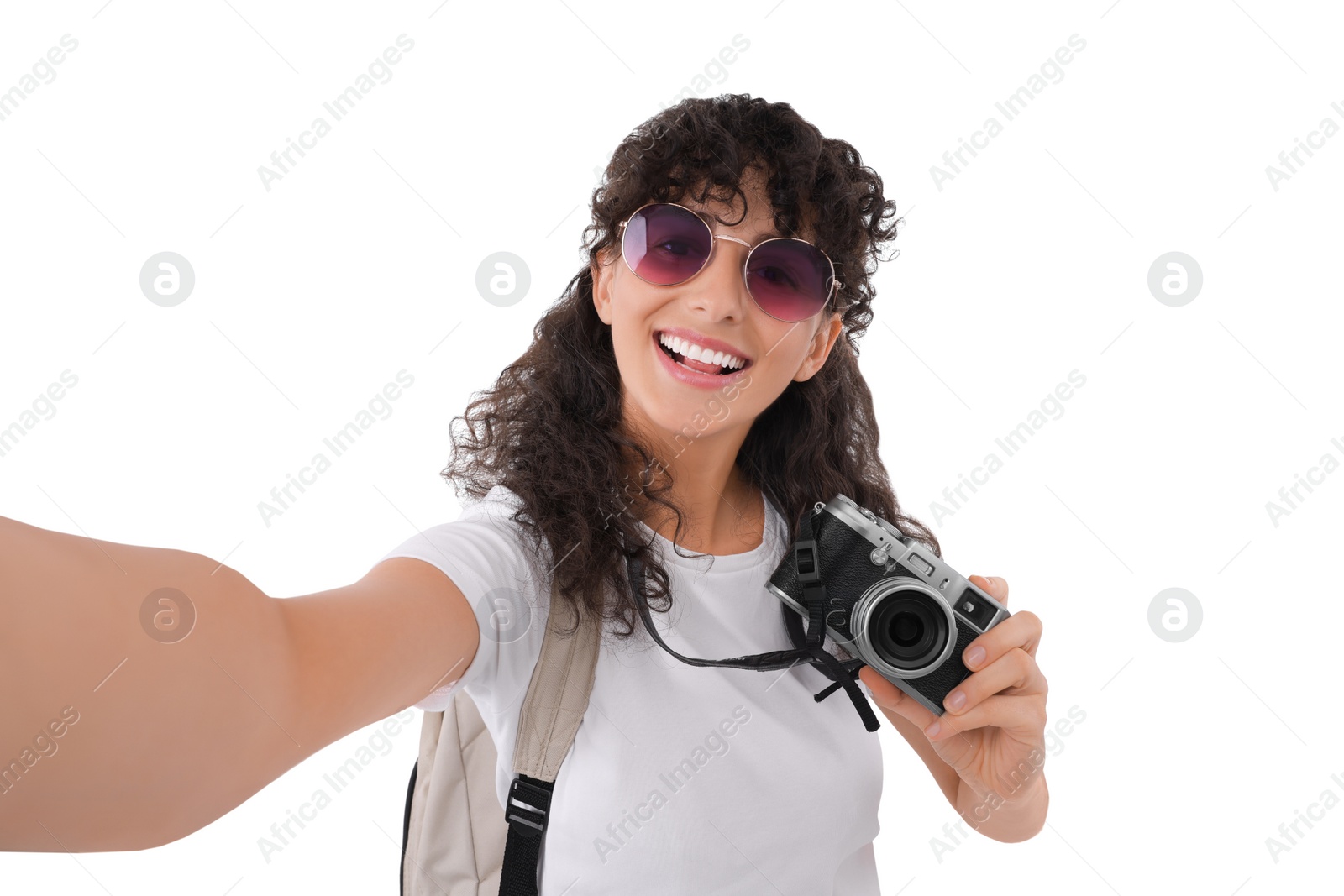 Photo of Beautiful woman in sunglasses with camera taking selfie on white background