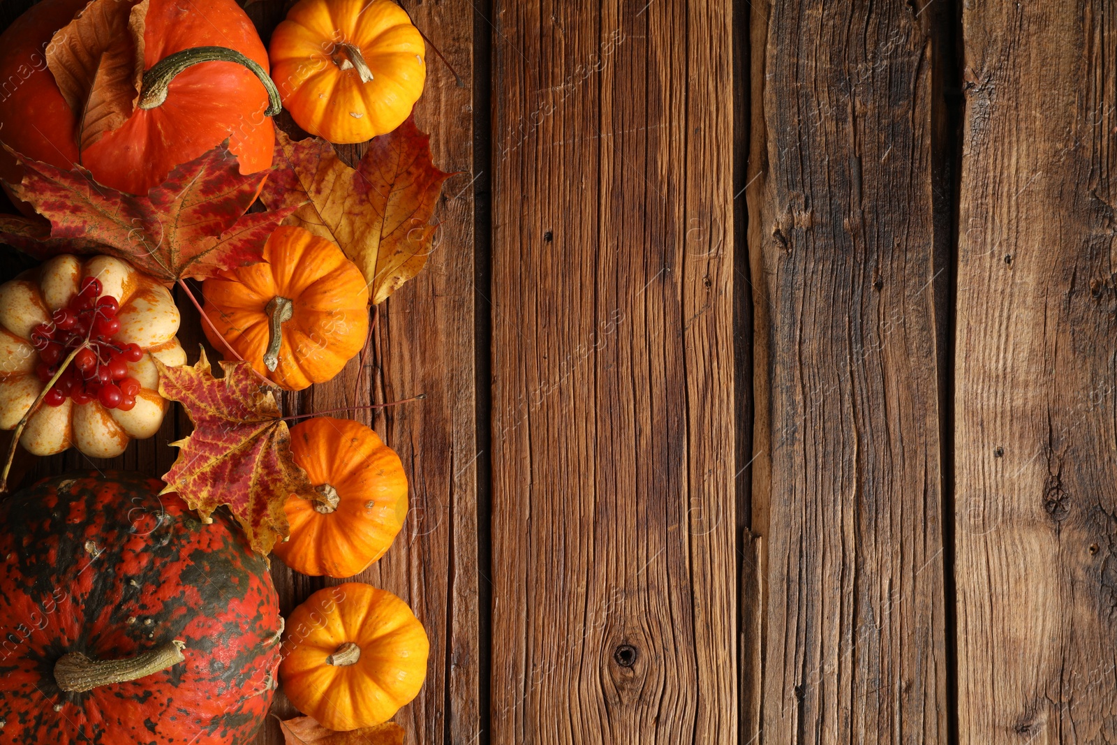 Photo of Dry autumn leaves and pumpkins on wooden table, flat lay. Space for text