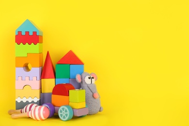Photo of Set of different toys on yellow background. Space for text