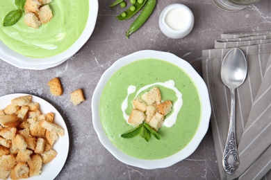 Photo of Flat lay composition with green pea soup on grey background