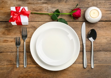 Beautiful table setting for Valentine's Day dinner on wooden background, flat lay