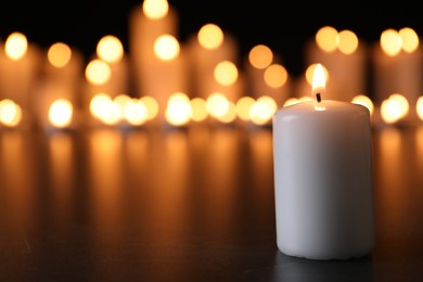 Burning candle on black table, space for text. Memory day