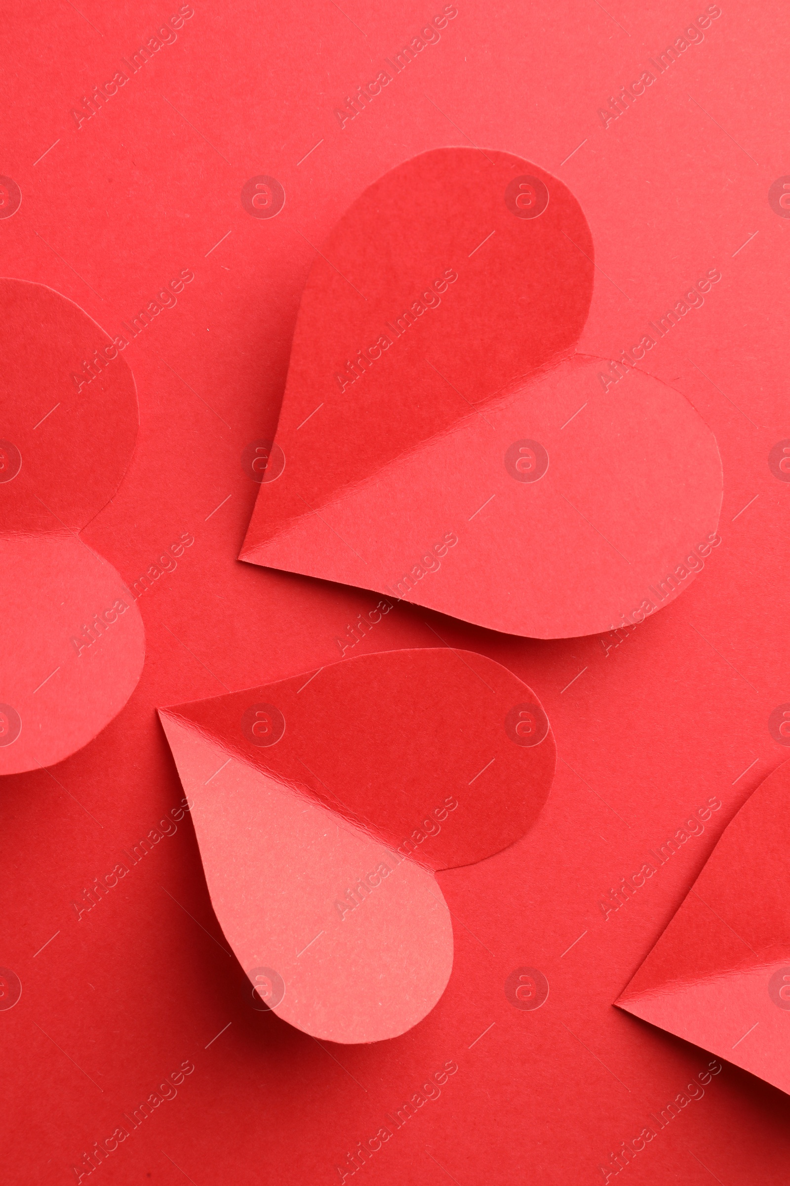 Photo of Paper hearts on red background, flat lay