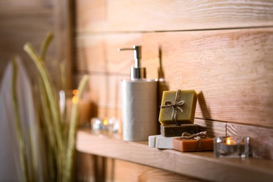 Photo of Soap bars and toiletries on wooden shelf. Space for text