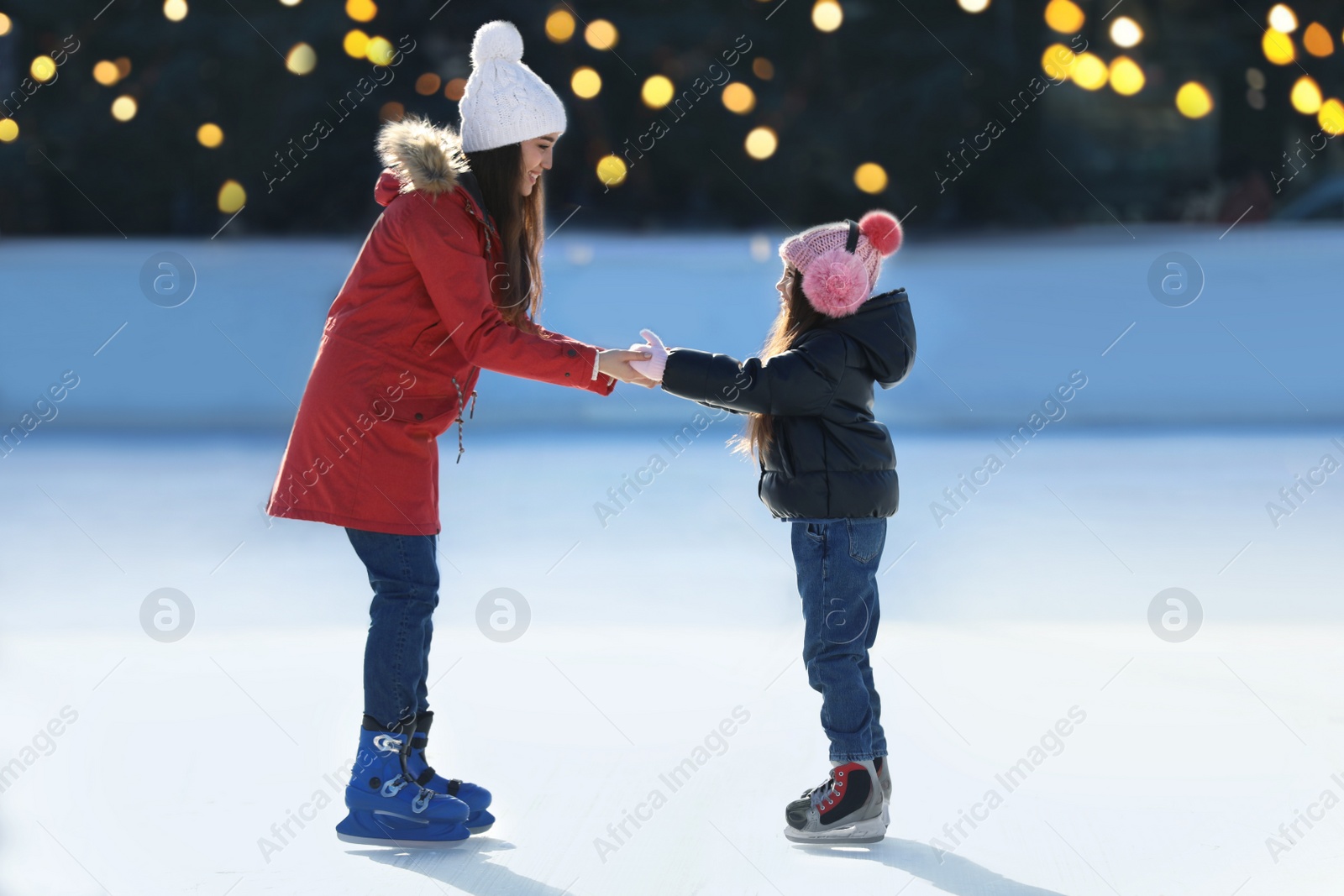 Image of Mother and daughter spending time together at outdoor ice skating rink