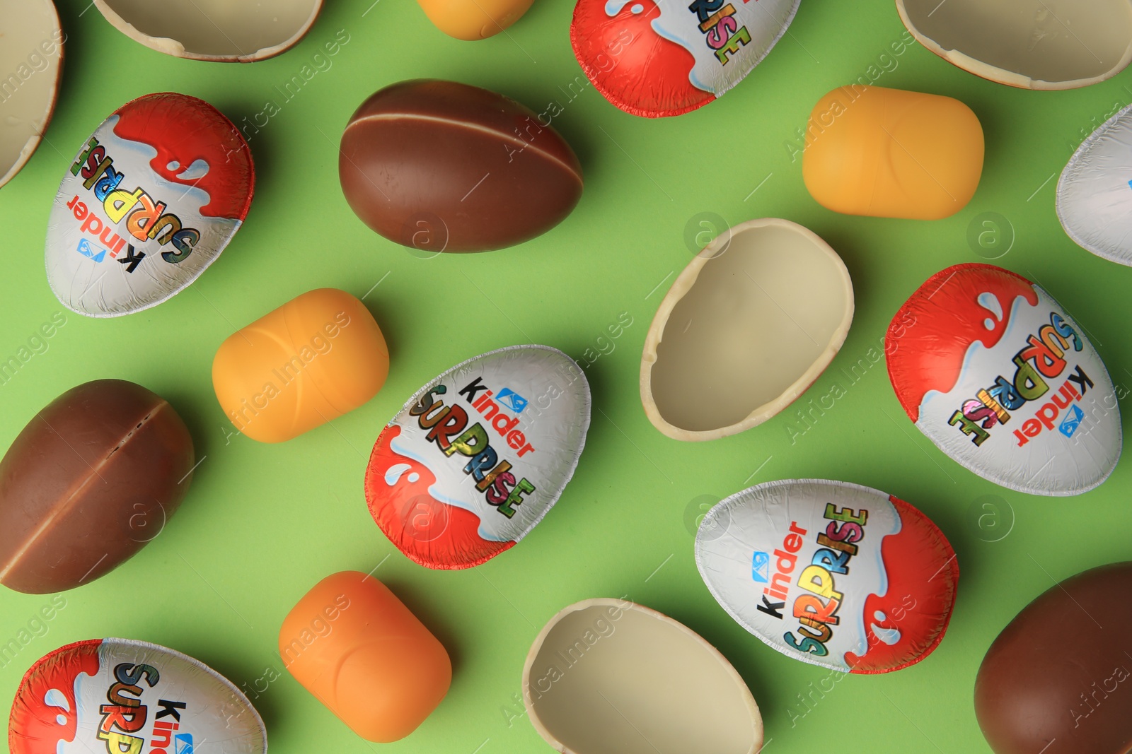 Photo of Sveti Vlas, Bulgaria - June 29, 2023: Kinder Surprise Eggs and plastic capsules on light green background, flat lay