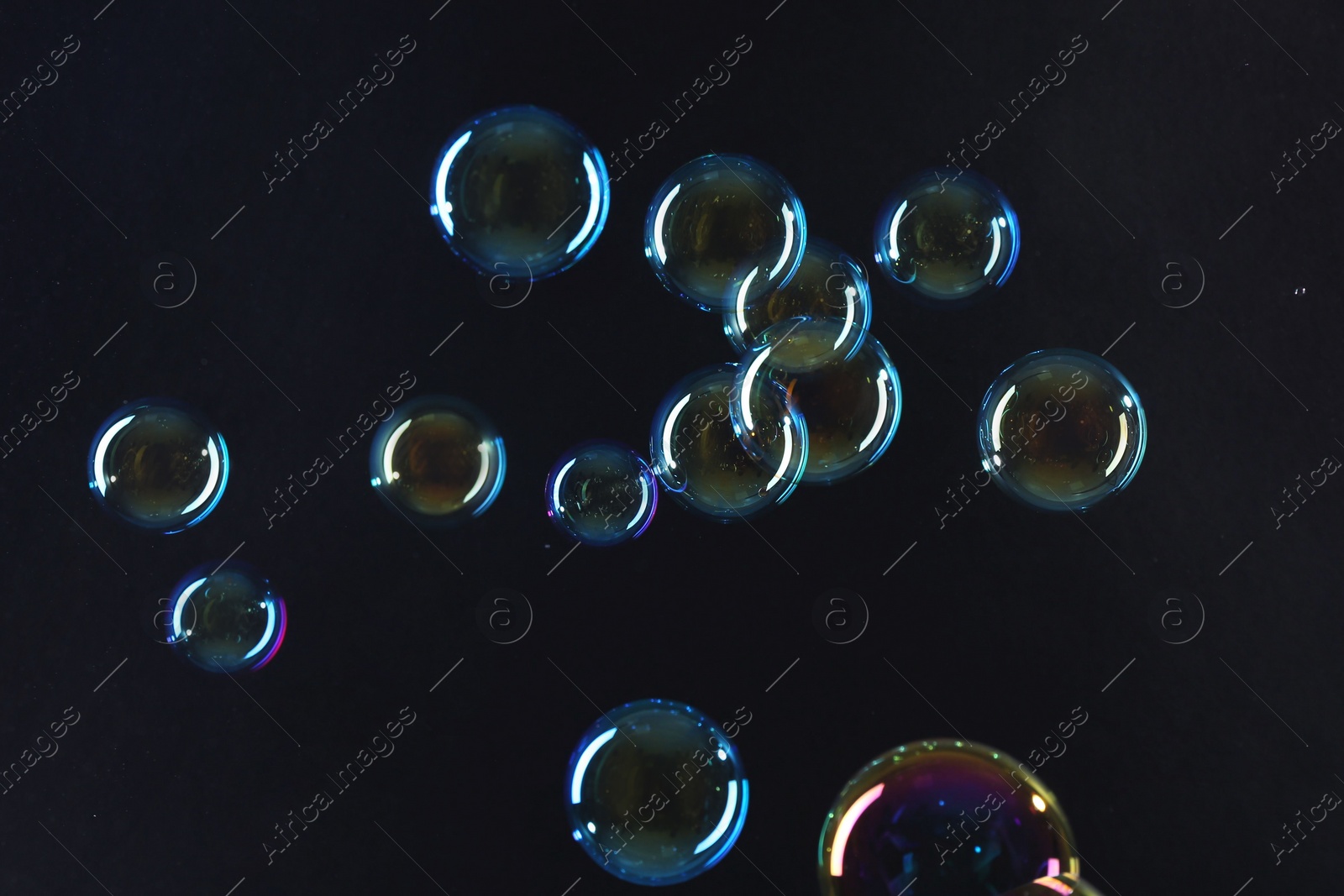 Photo of Beautiful transparent soap bubbles on dark background