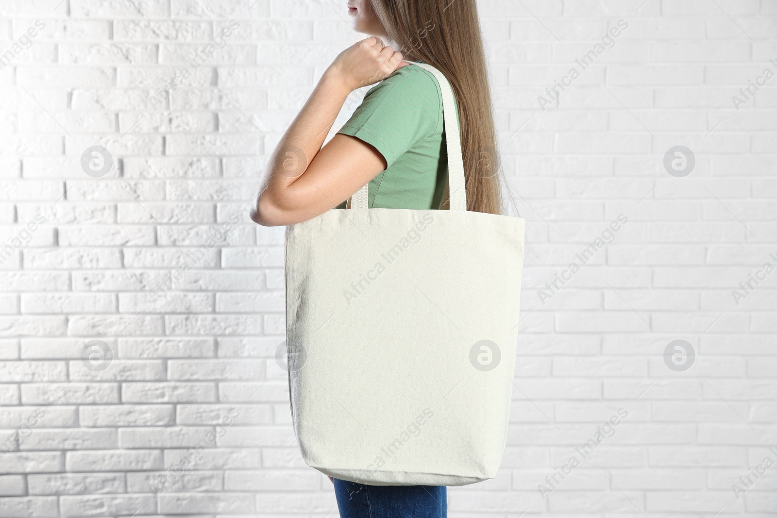 Photo of Woman with eco bag near brick wall. Mock up for design