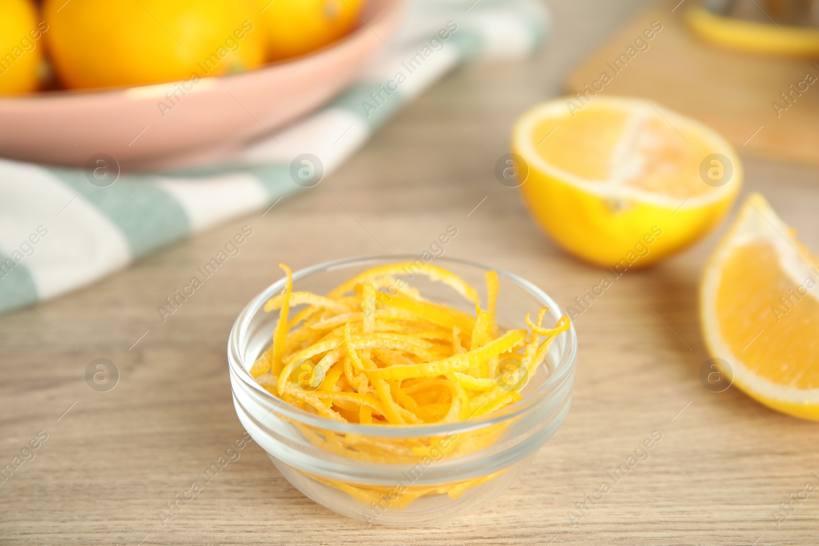 Photo of Grated lemon zest and fresh fruits on wooden table