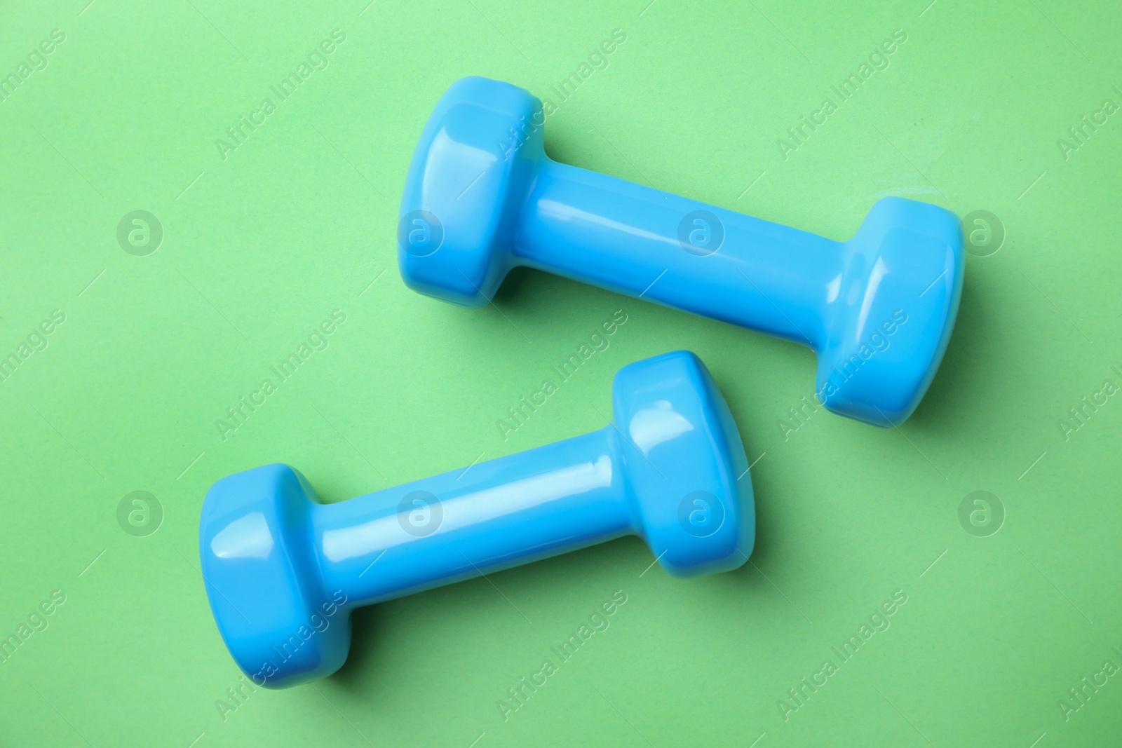 Photo of Bright dumbbells on color background, flat lay. Home fitness