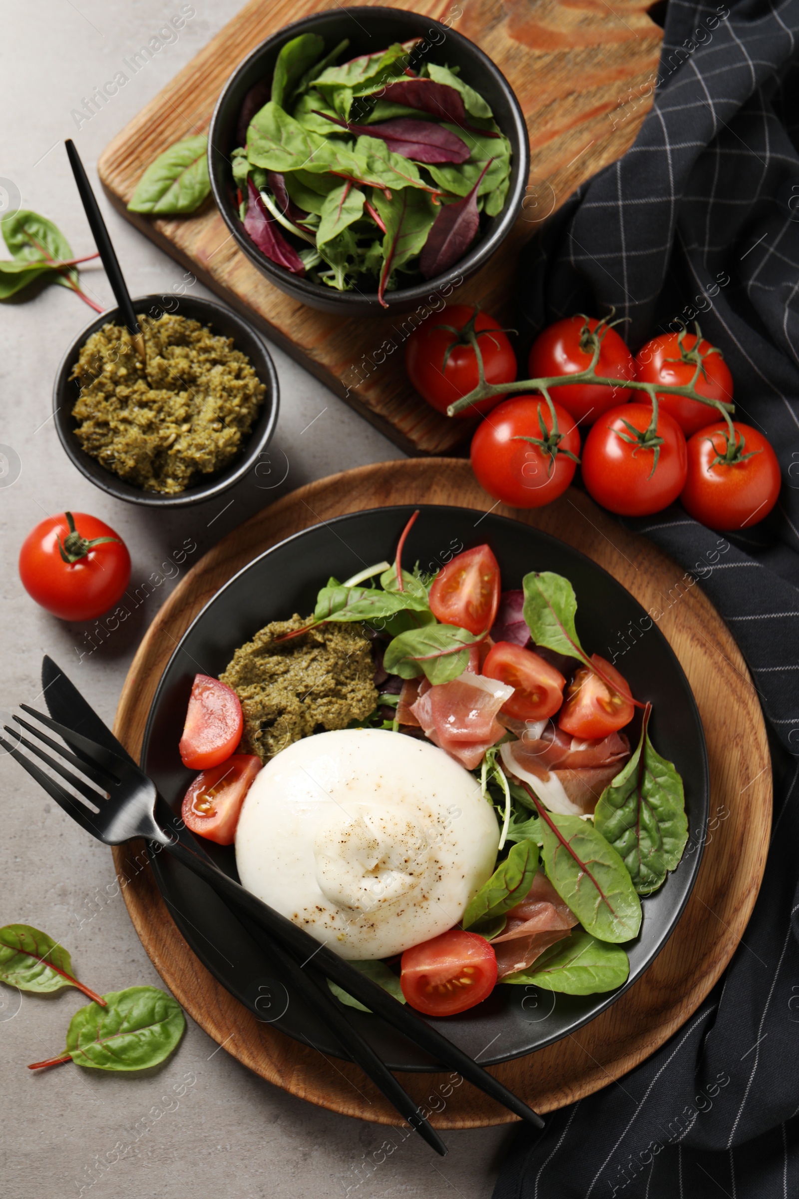 Photo of Delicious burrata salad served on light grey table, flat lay