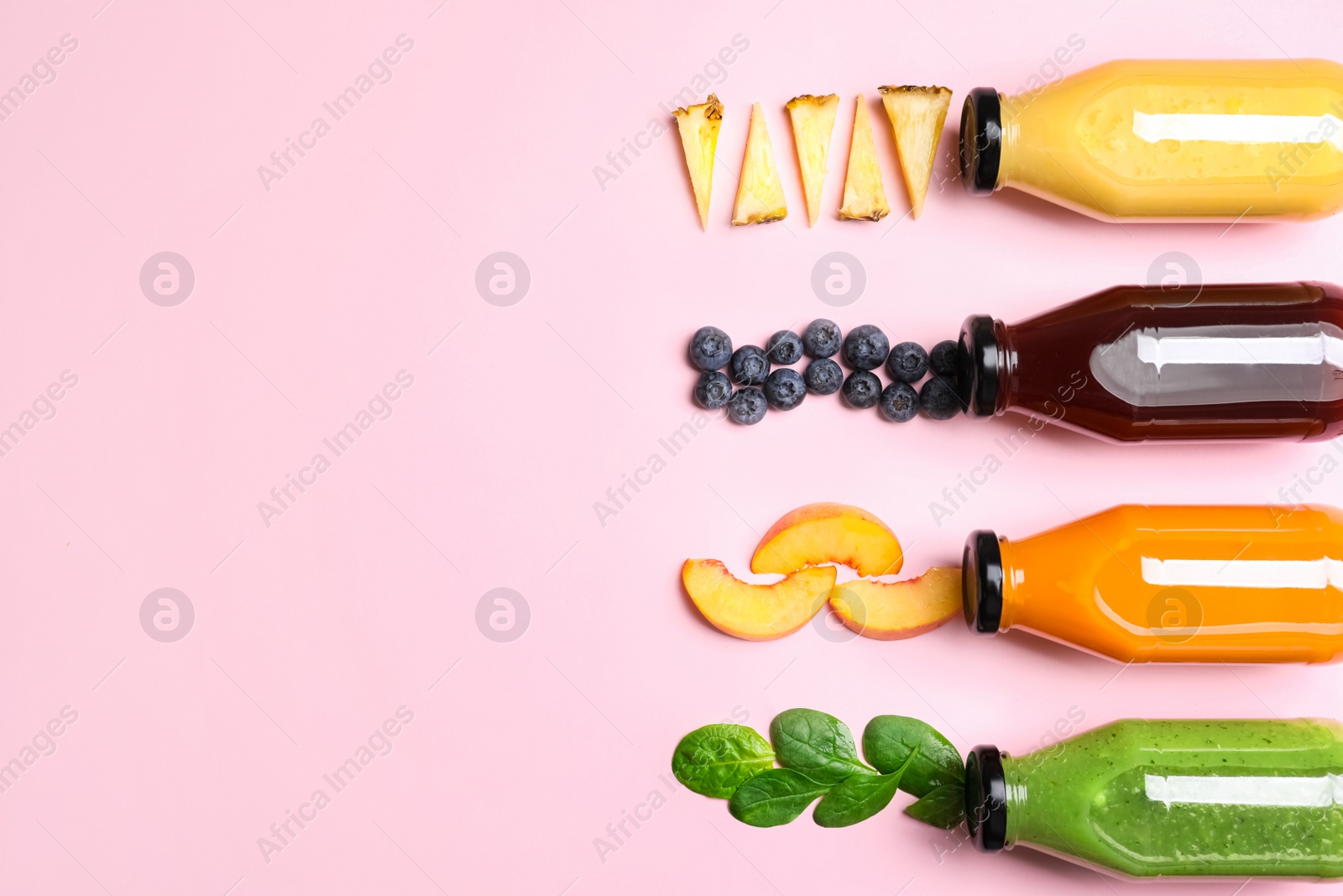 Photo of Flat lay composition with bottles of colorful juices and fresh ingredients on pink background. Space for text