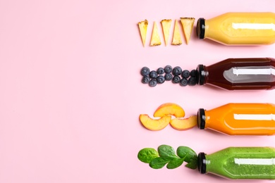 Photo of Flat lay composition with bottles of colorful juices and fresh ingredients on pink background. Space for text