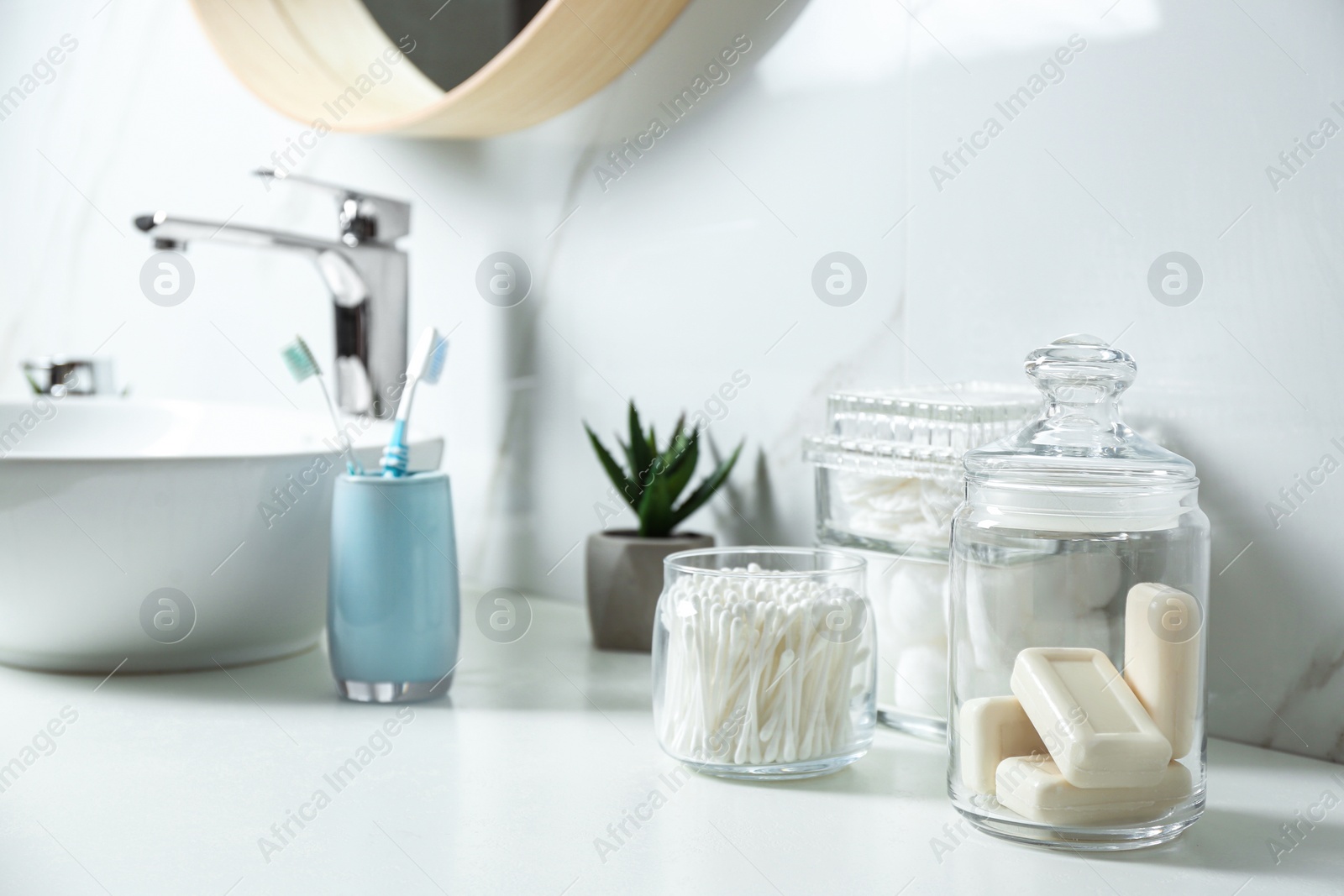Photo of Cotton swabs and soap bars on white countertop in bathroom