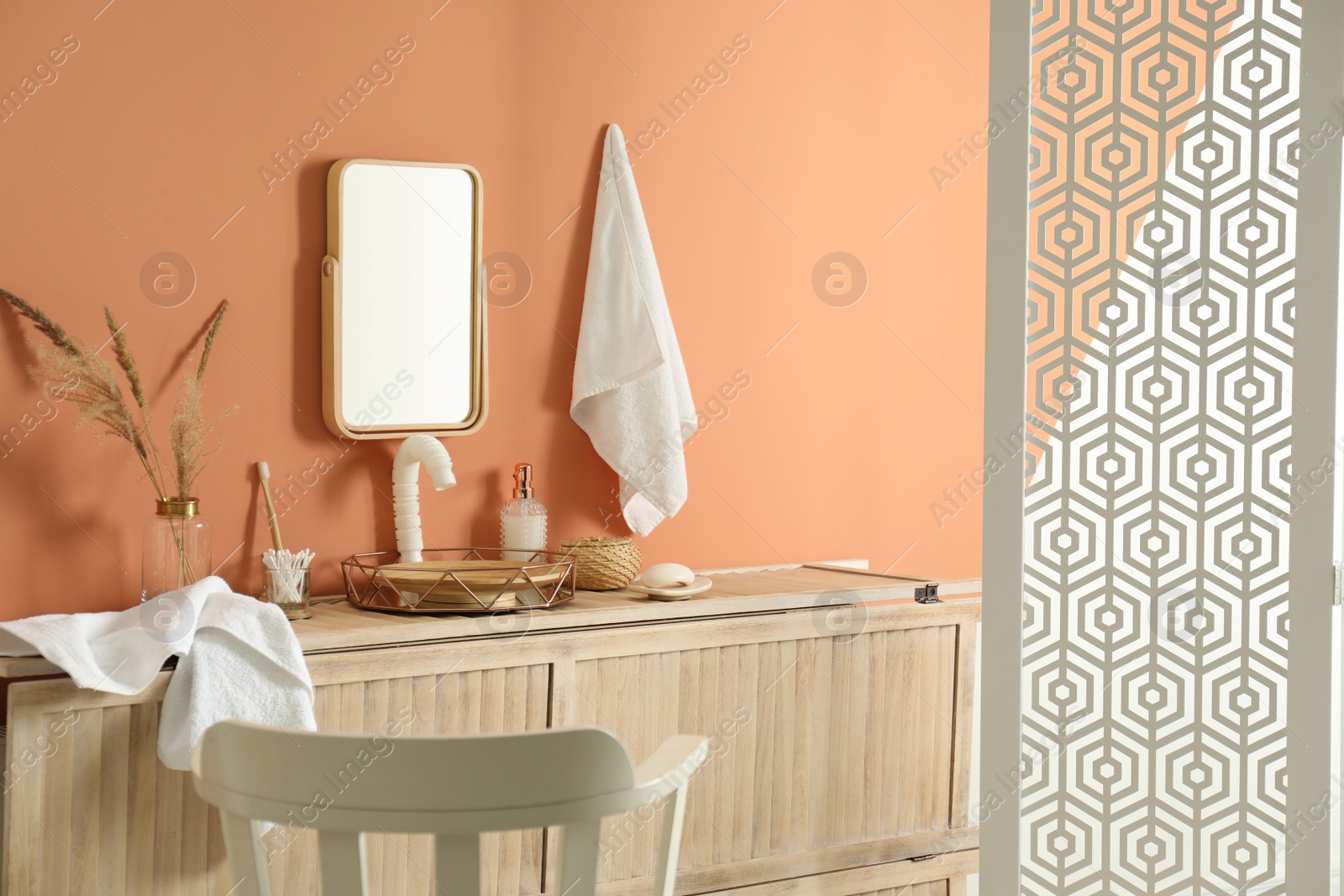 Photo of Modern bathroom interior with wooden commode and folding screen