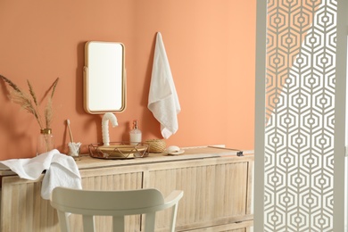 Modern bathroom interior with wooden commode and folding screen