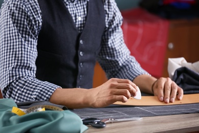 Tailor working at table in atelier, closeup