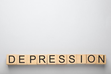 Word Depression made of wooden cubes on white background, flat lay. Space for text