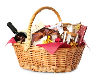 Photo of Wicker basket full of gifts isolated on white