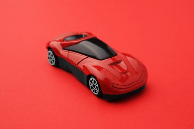 Photo of One bright car on red background. Children`s toy