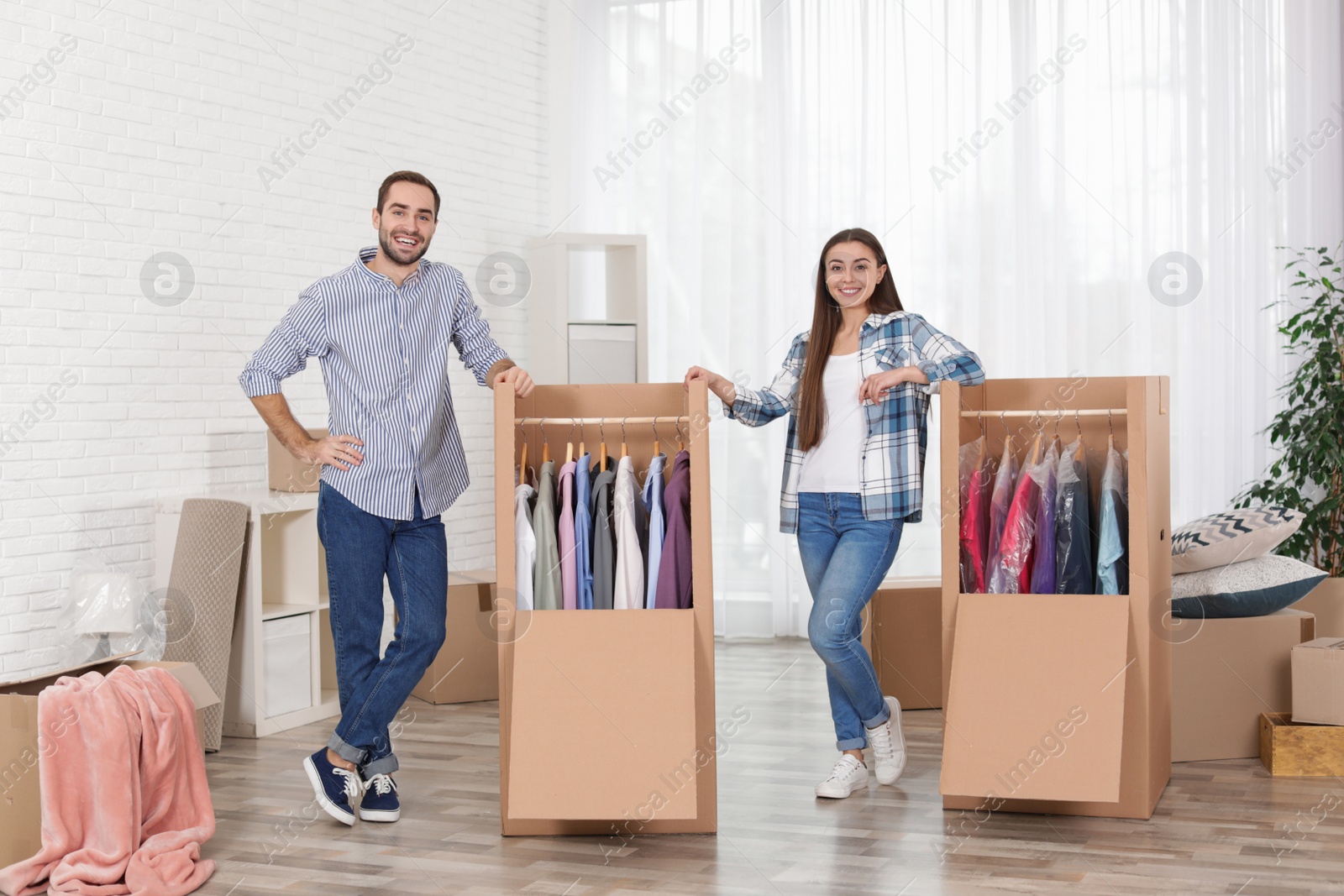 Photo of Young couple near wardrobe boxes at home