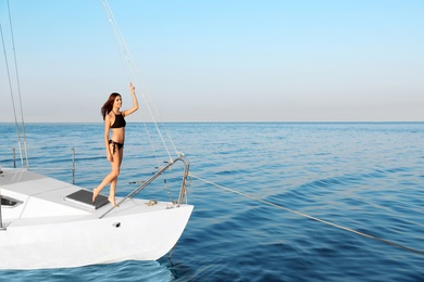 Beautiful woman in bikini relaxing on yacht during sea trip