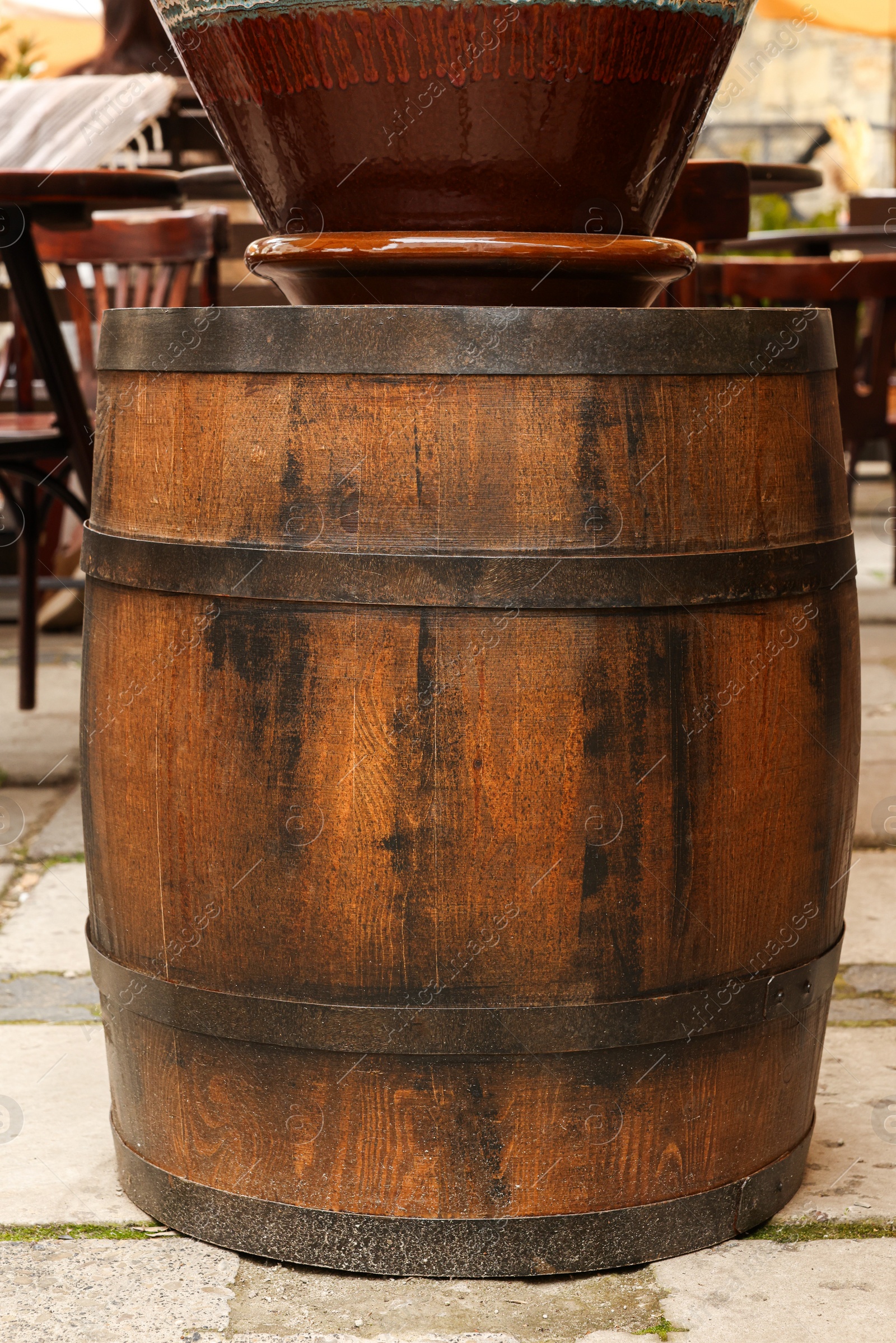 Photo of Traditional wooden barrel on street outdoors. Wine making