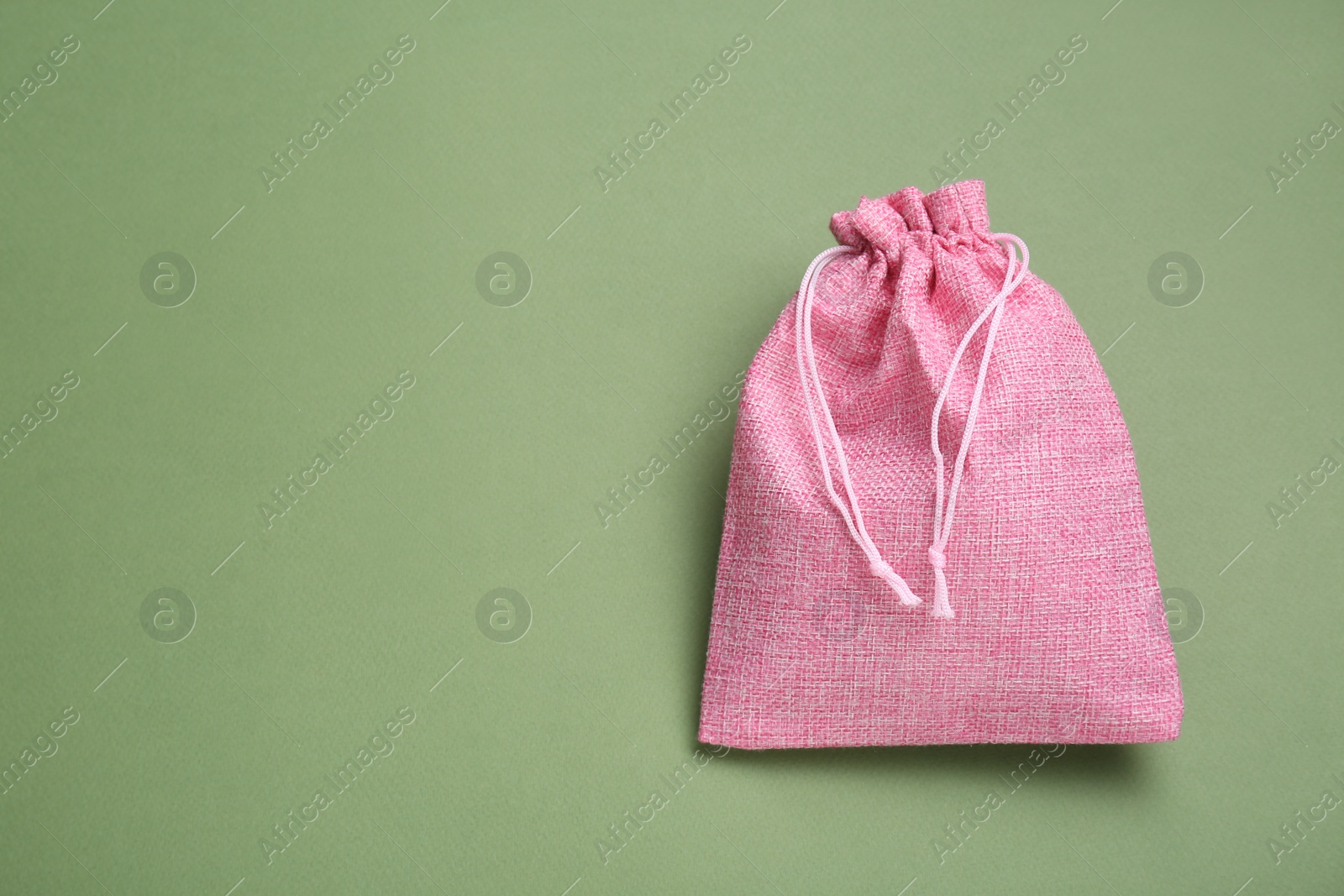 Photo of Pink burlap bag on olive background, top view. Space for text